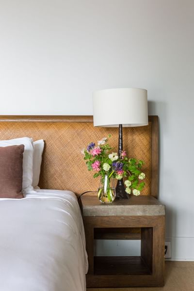 Flower vase & a lamp next to a bed at Heritage House Resort