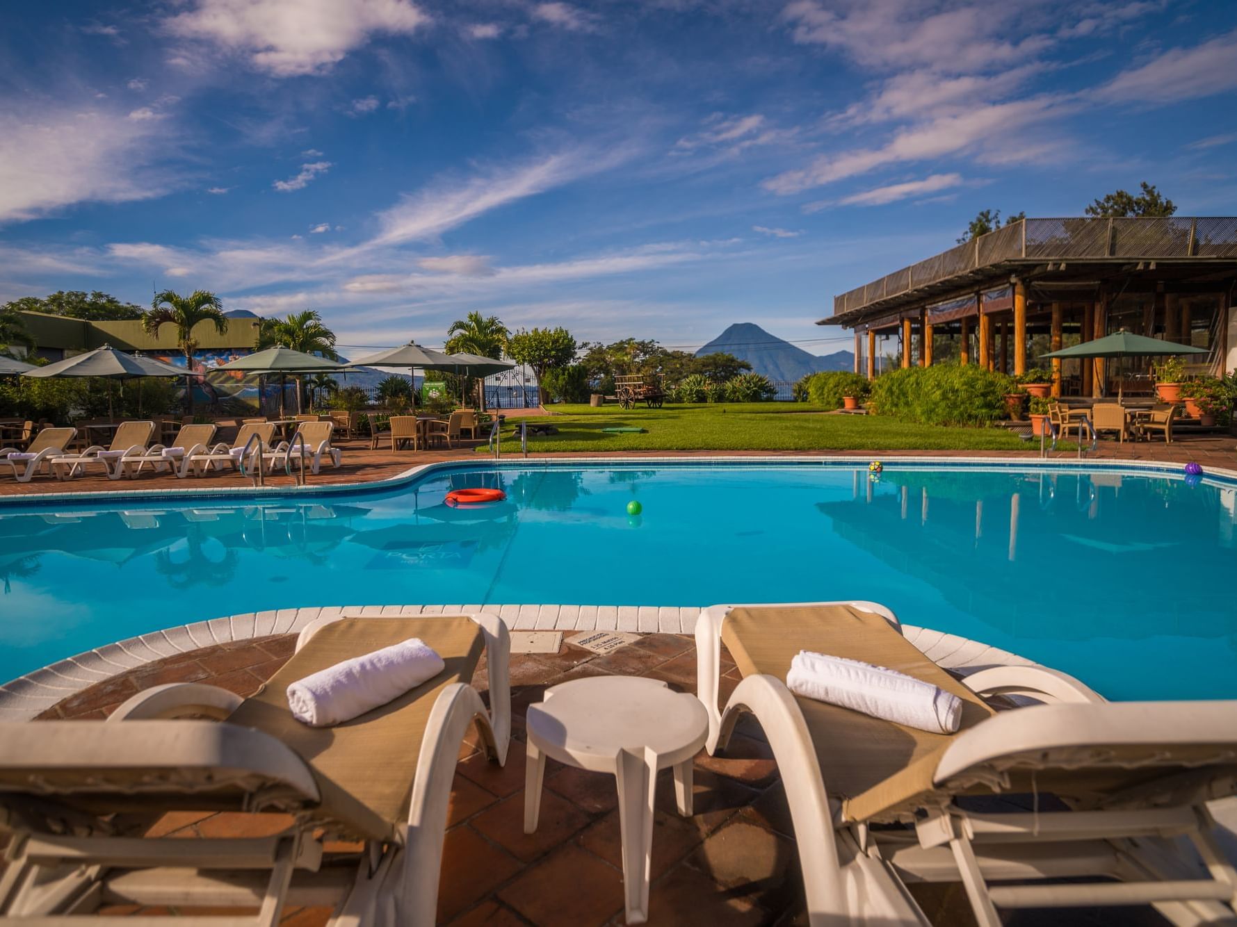 Relaxing lounge area by the outdoor pool overlooking the mountains at Porta Hotel del Lago