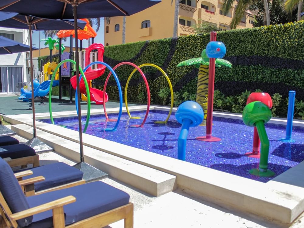 Colorful outdoor kids' splash pad with water slides and vibrant play features on a sunny day at Sunvivia Mazatlán