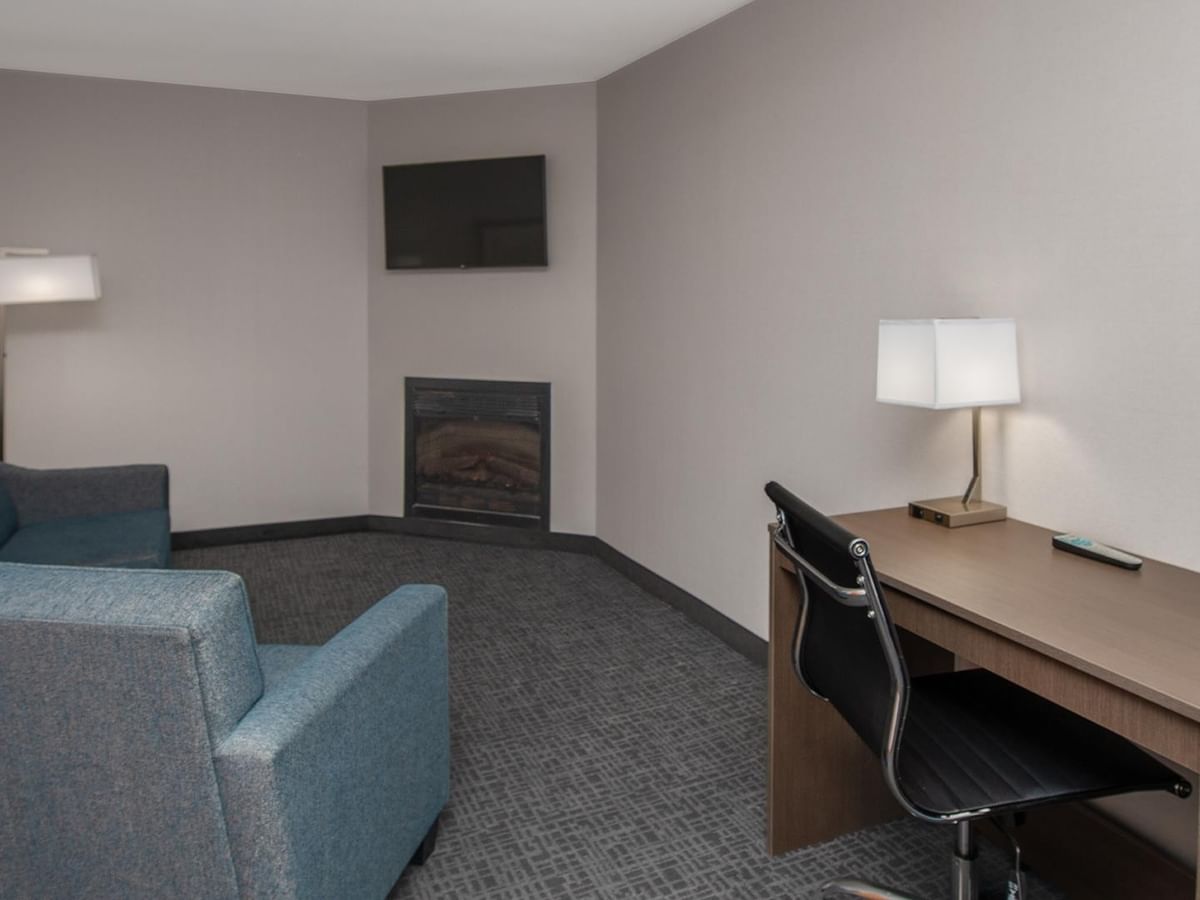 Living area with couch, fireplace, and work desk.