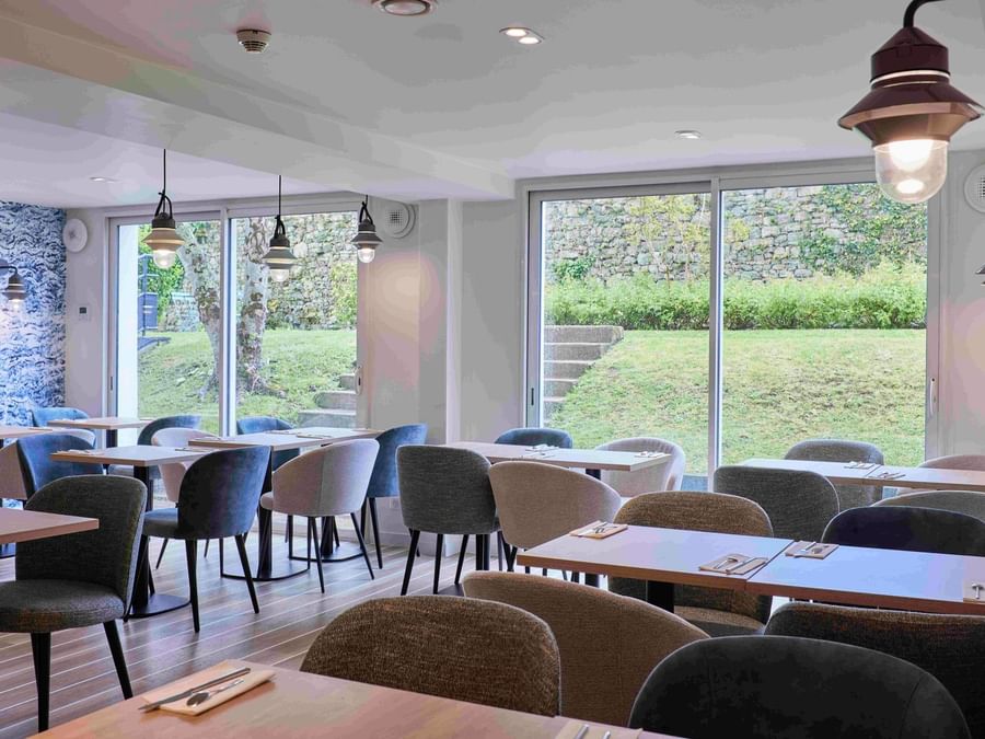 Salle à manger moderne avec vue sur le jardin à Hôtel La Marébaudière.