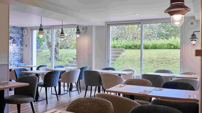 Salle à manger moderne avec vue sur le jardin à Hôtel La Marébaudière.