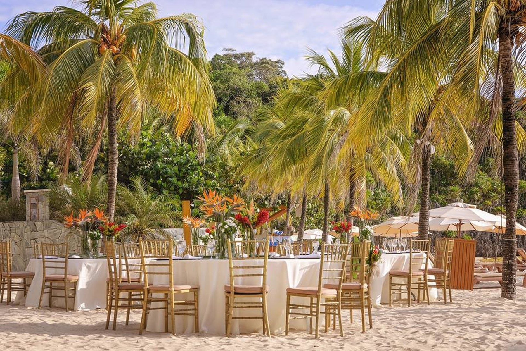 tables set on beach near palm trees