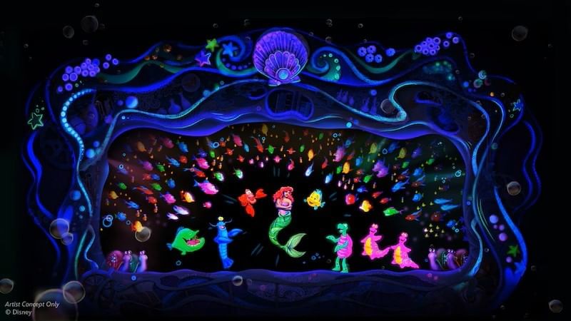 A dark stage with dozens of neon fish and other underwater creatures, including a mermaid, glowing in the darkness.