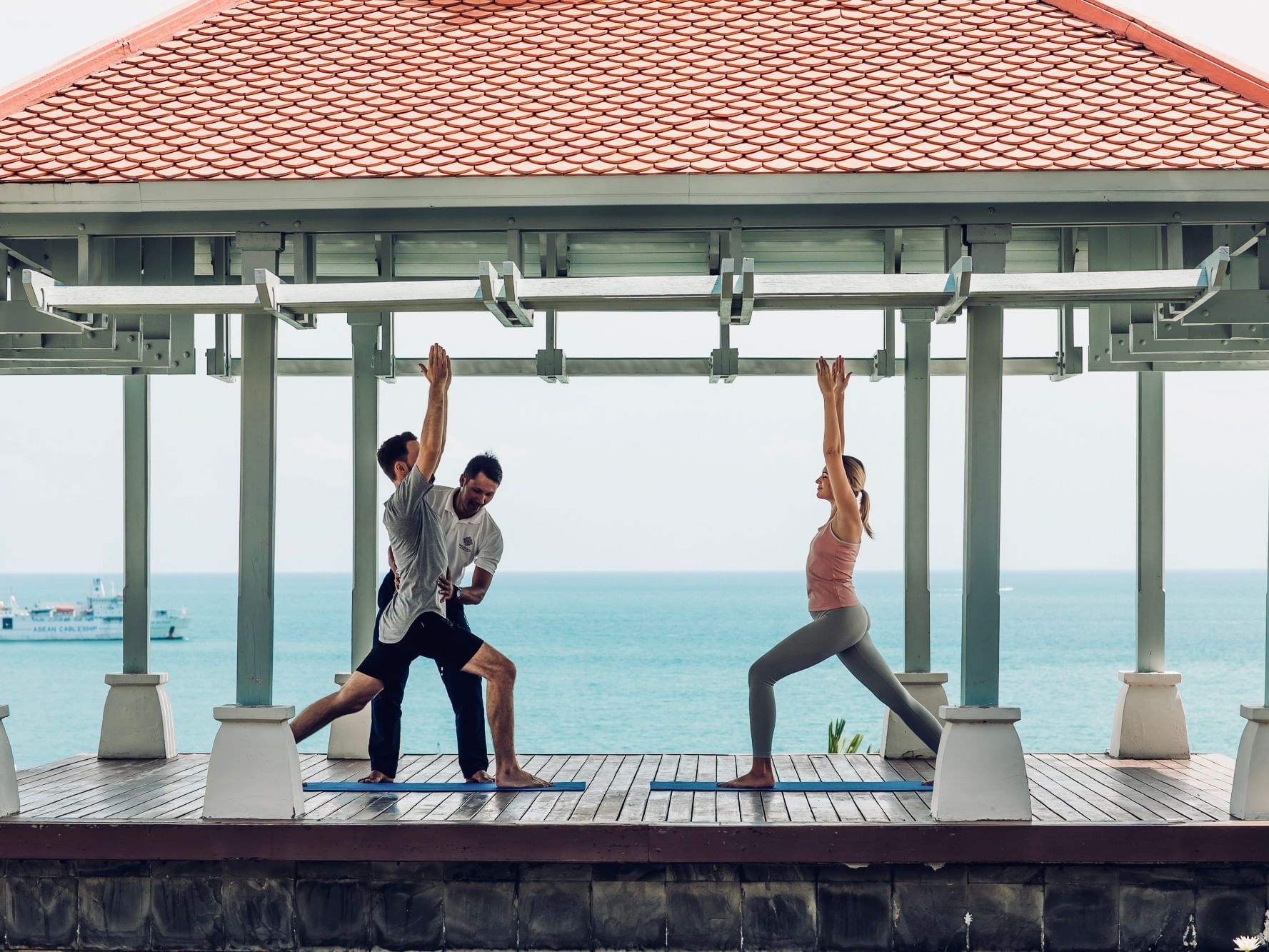 A couple doing yoga with instructor at Amatara Wellness Resort