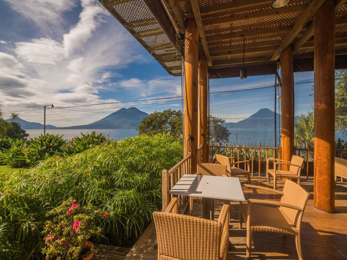 Outdoor patio with dining tables overlooking the mountain view in El Mirador Snack Bar at Porta Hotel del Lago