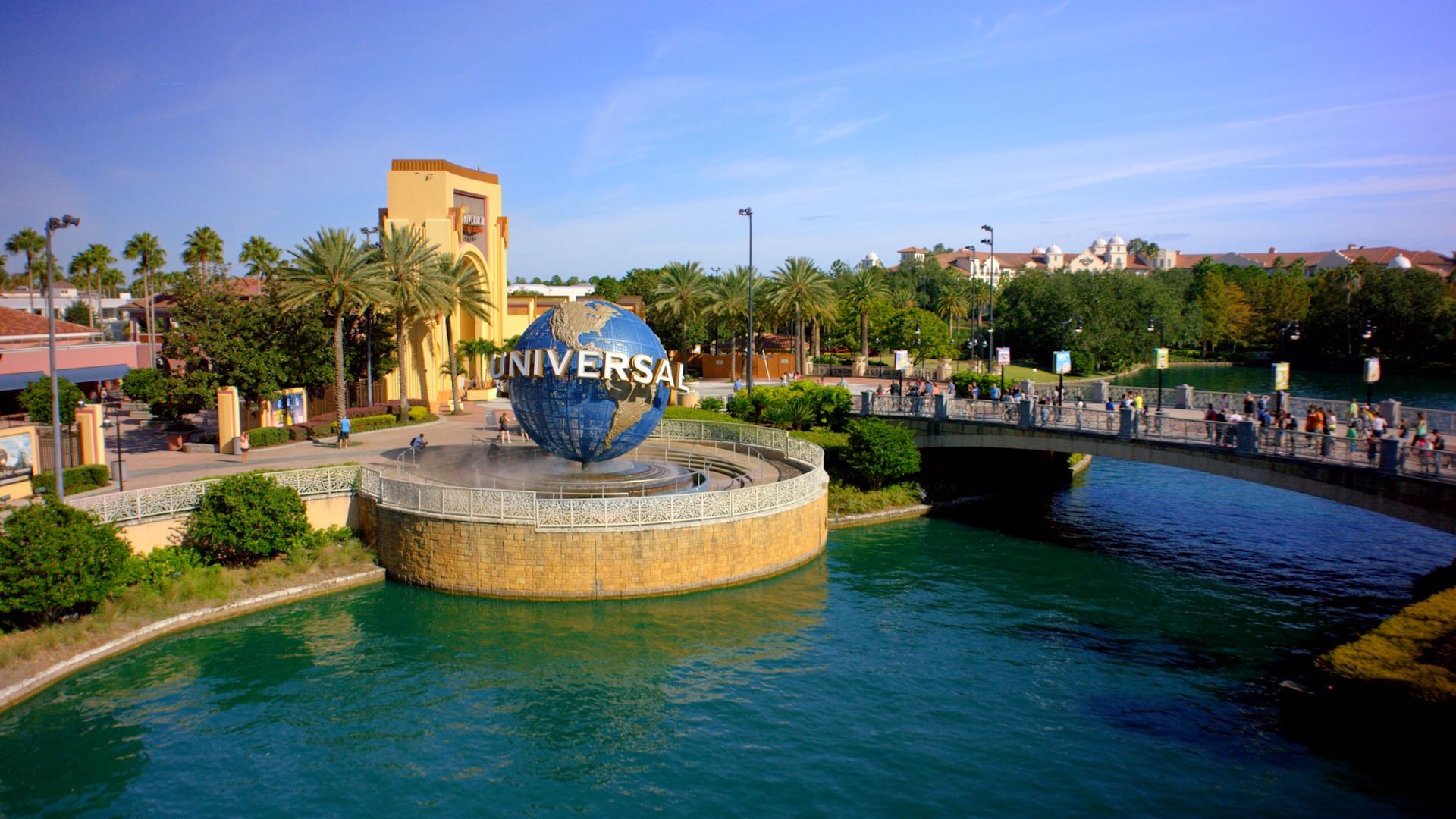 A large river beneath a bridge and a circular patio with the iconic Universal globe.