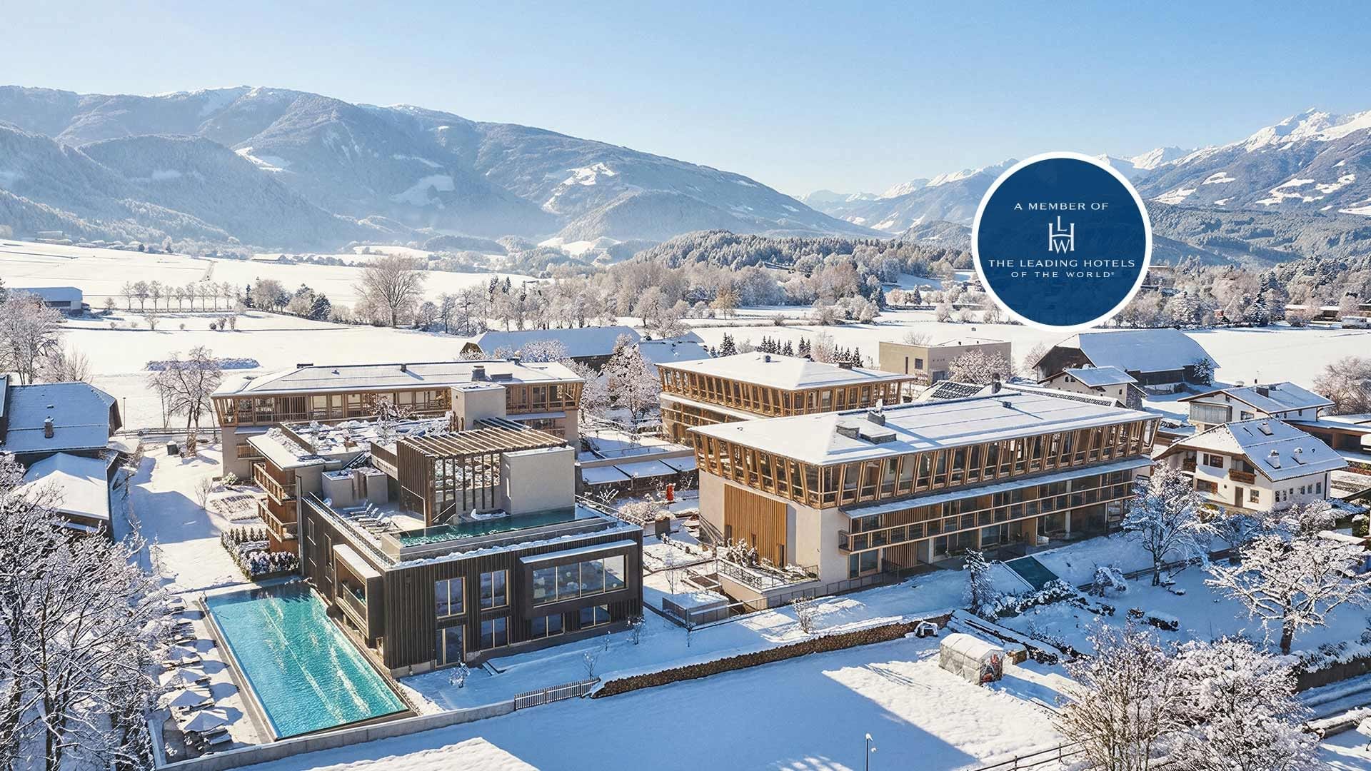 Hotel surrounded by snow-covered landscape and mountains at Falkensteiner Hotel Kronplatz