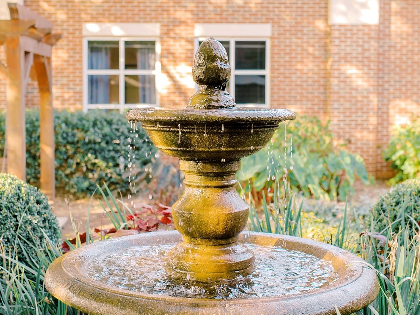 Fountain in patio area with landscaped area surrounding