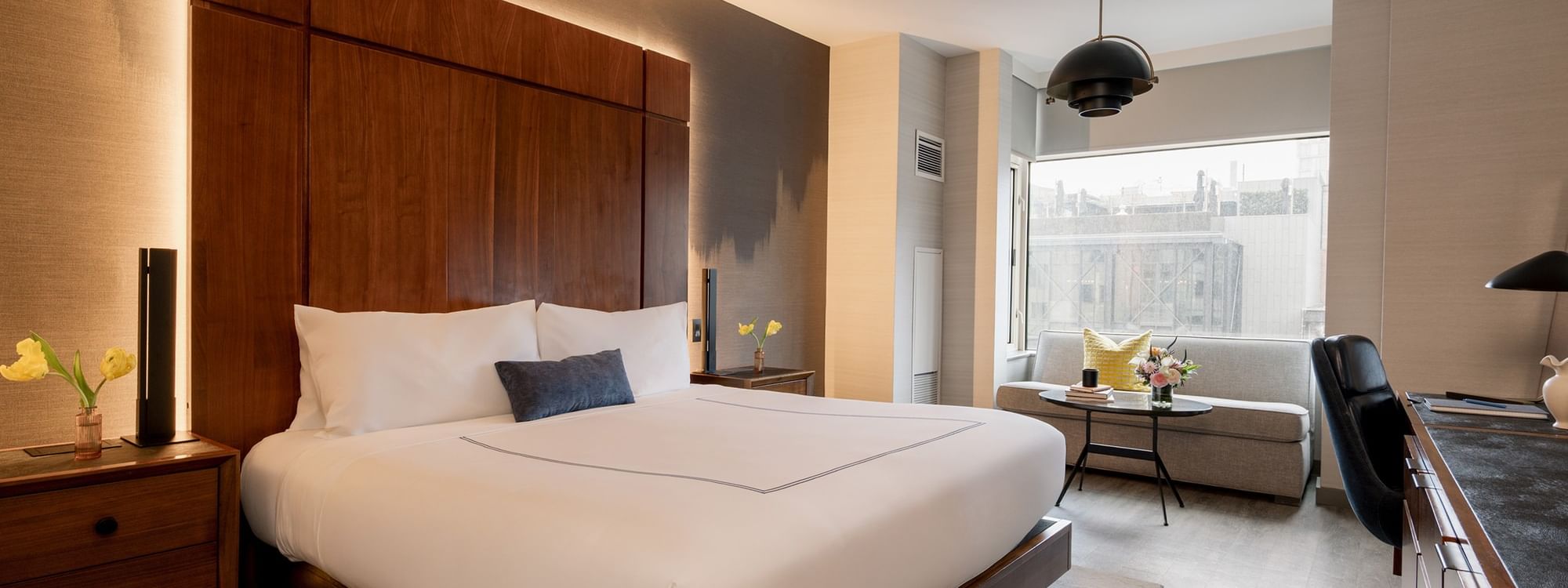 Elegantly designed Deluxe Room with modern furniture and a cityscape view at Gansevoort Meatpacking NYC in New York.
