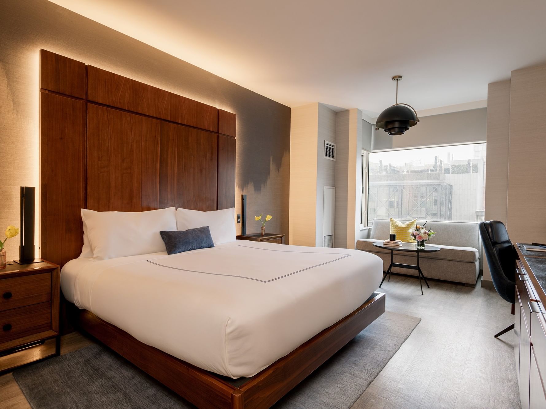 Elegantly designed Deluxe Room with modern furniture and a cityscape view at Gansevoort Meatpacking NYC in New York.