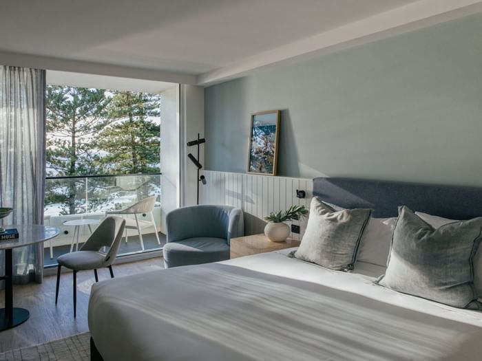 Ocean View Two Bedroom at Elysium Hotels bed with grey pillows beside a nightstand and framed wall art nearby