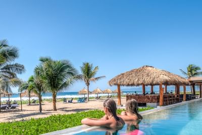 Two ladies relaxing in a pool at Marea Beachfront Villas