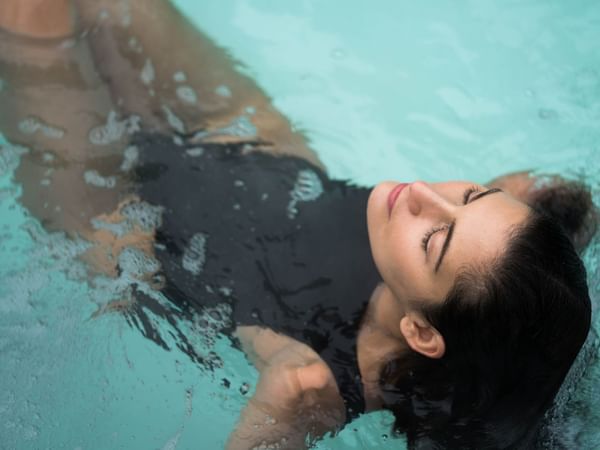 Girl relaxing in a pool at Warwick Le Crystal