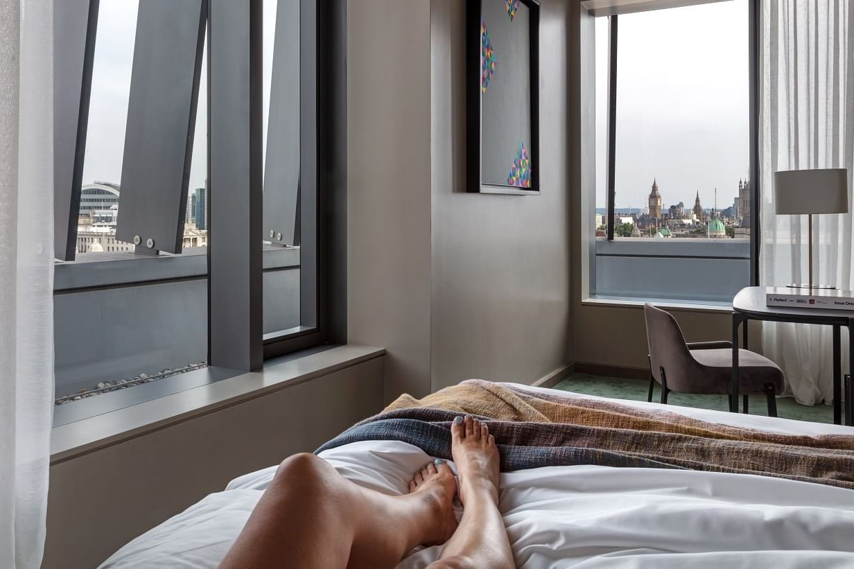 Relaxing Deluxe King bedroom at The Londoner, featuring elegant decor and a stunning outdoor view