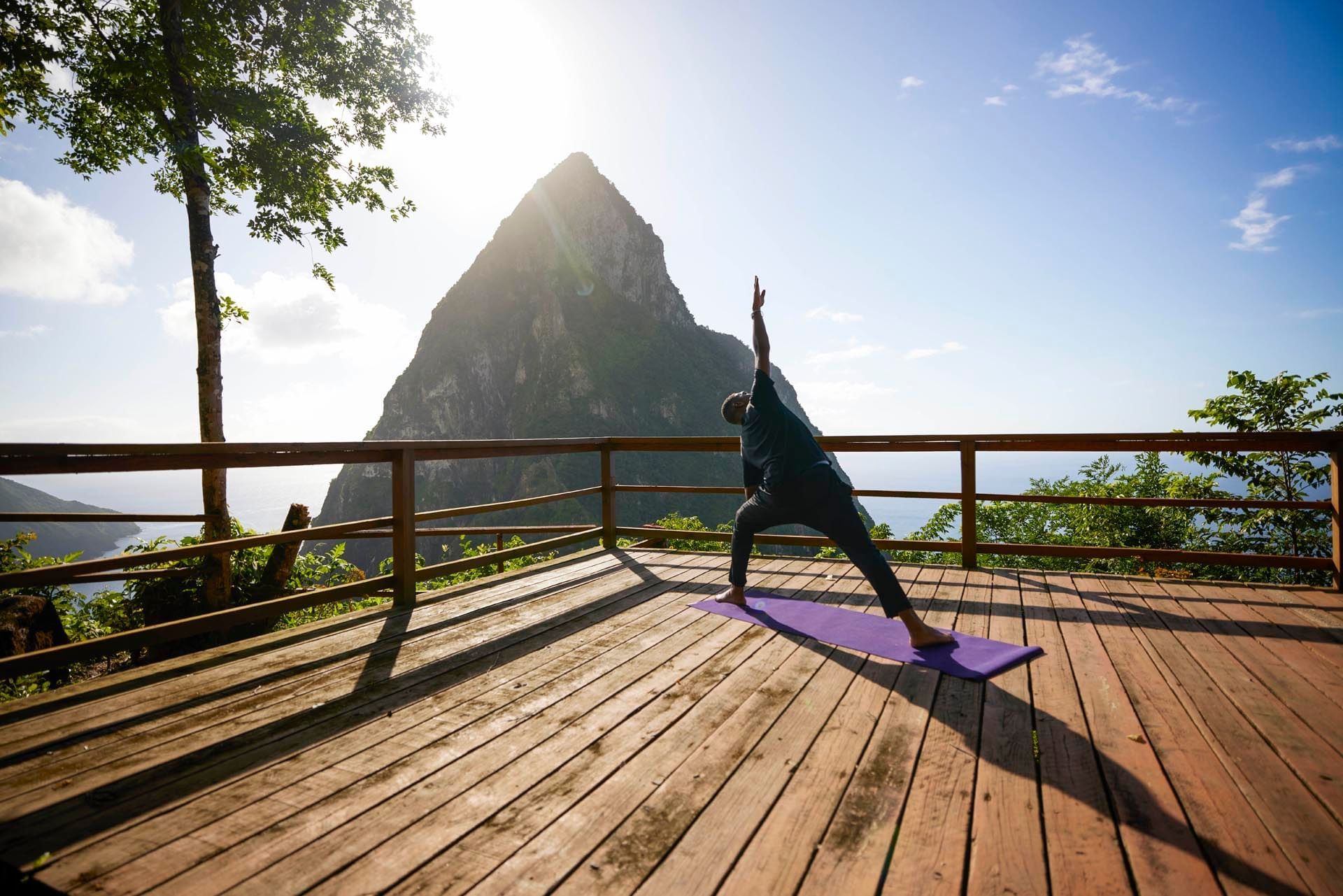 A man doing yoga on a wooden deck on a sunny day at Ladera Resort