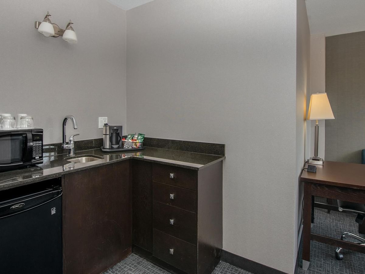 Microwave, sink, and coffee maker in a hotel suite.