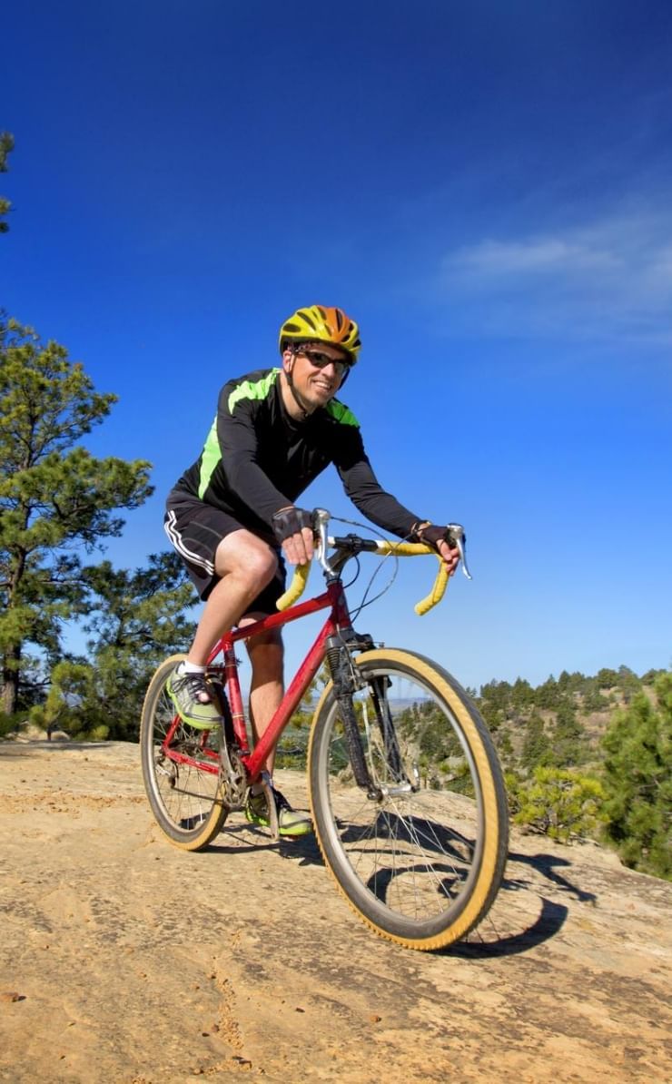 Man cycling at Swords Rimrock Park on a sunny day near Boothill Inn & Suites