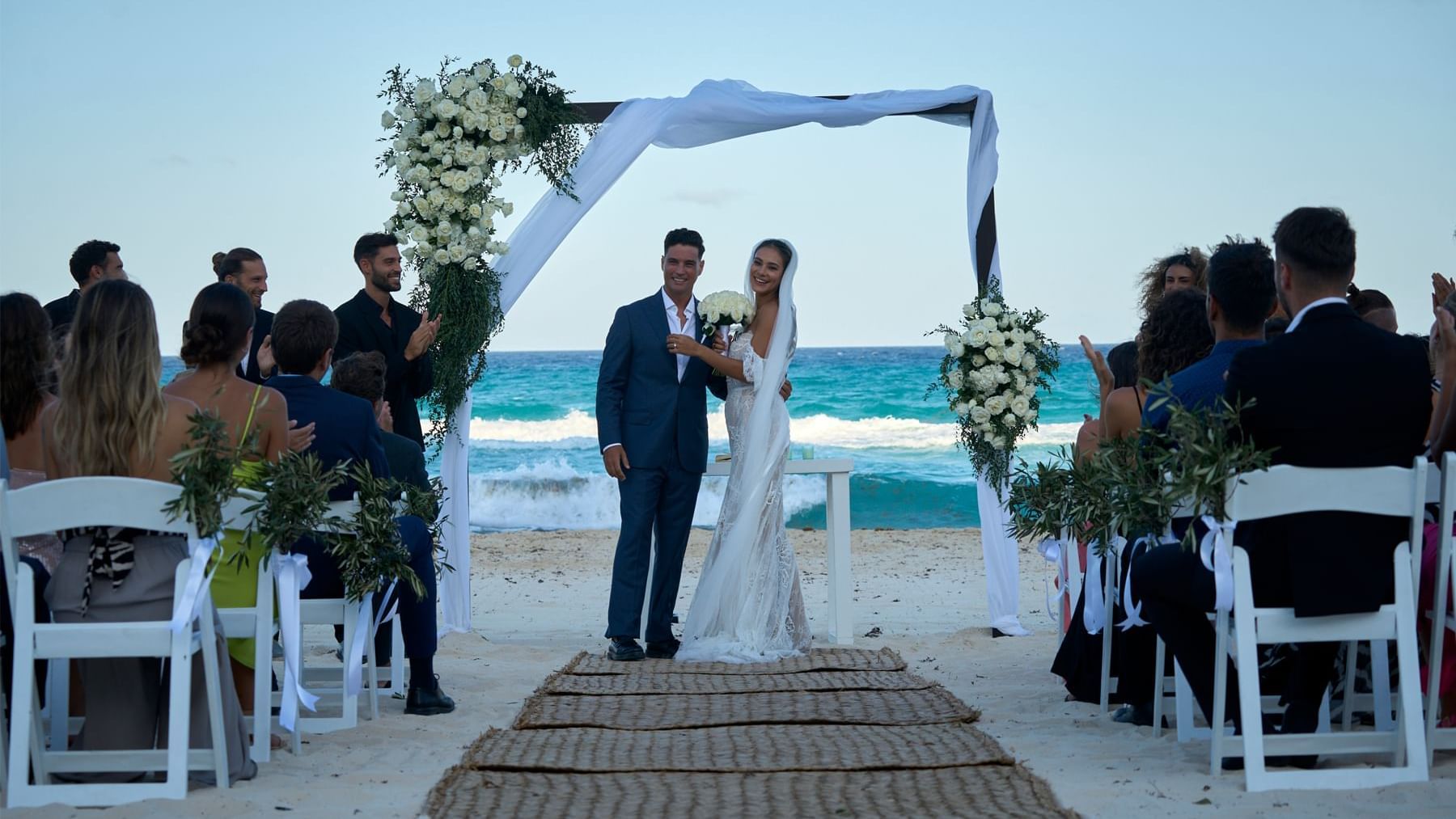 Wedded couple posing for a photo near the beach at Fiesta Americana