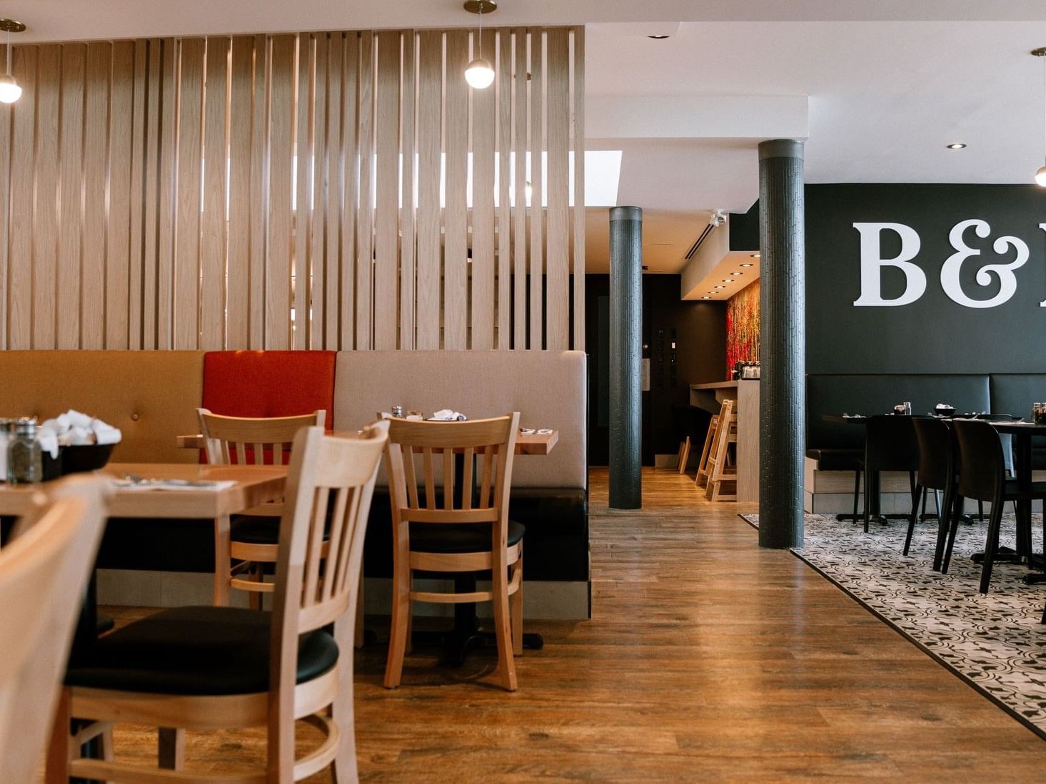 Elegant dining area with wooden tables and chairs at Ruby Foo's Hotel Montreal.