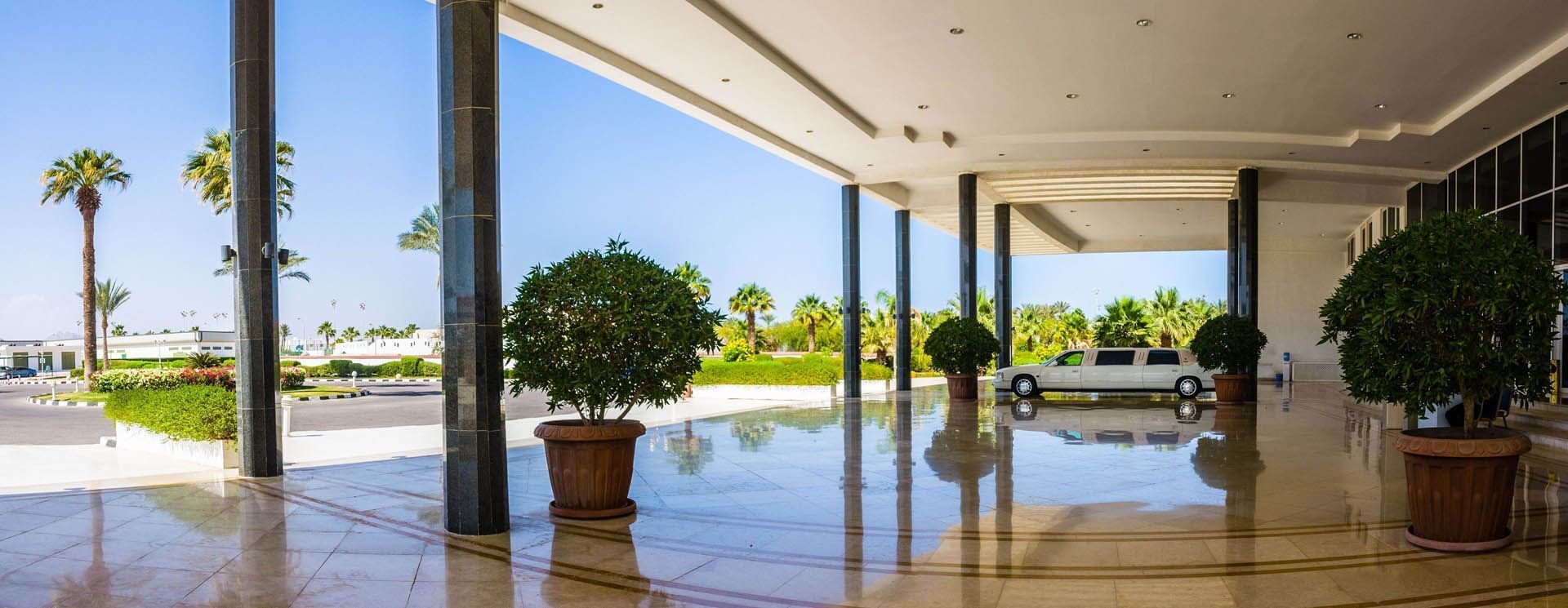 Spacious entrance at Pickalbatros Golf Beach Resort, with polished floors, potted plants, and a white limousine