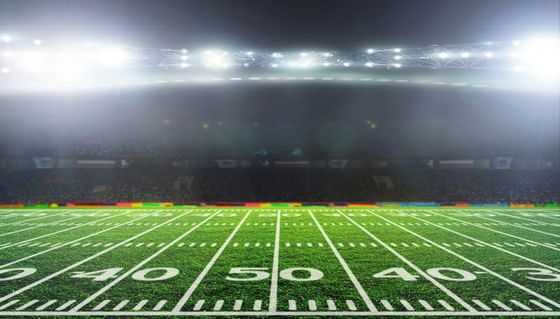 Football field with yard lines fading into fog under bright stadium lights near Paramount Hotel Seattle