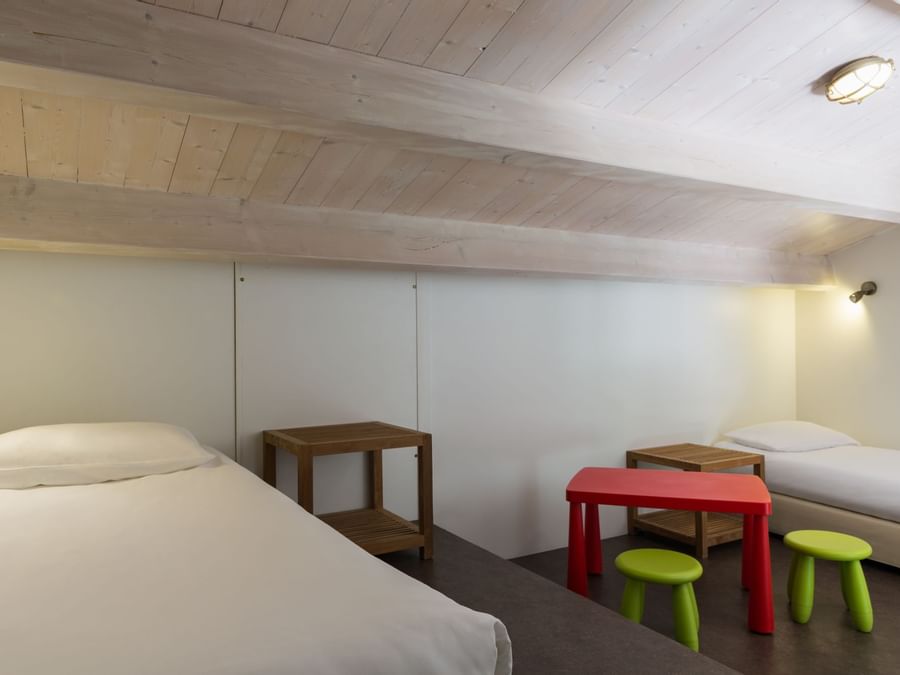 Two beds & furniture in a bedroom at Les Vignes de la Chapelle