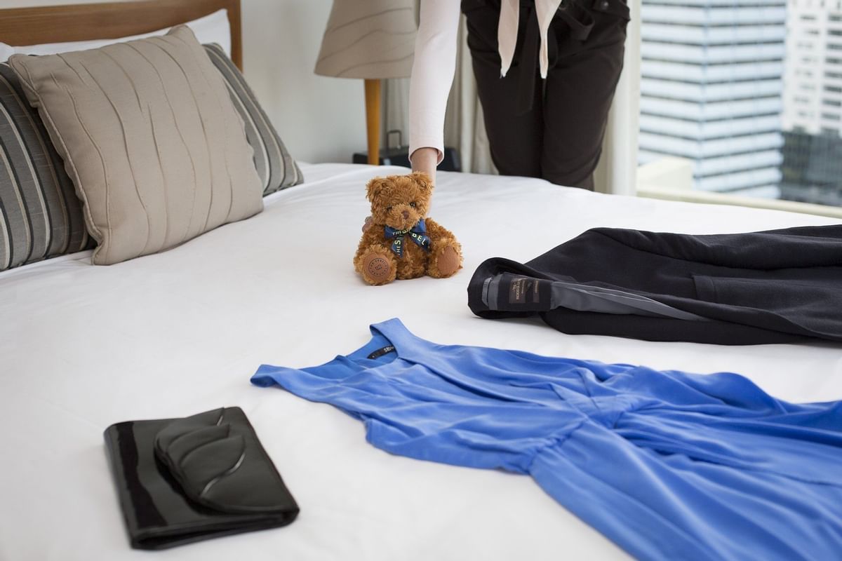 Teddy and clothes on the bed at the Sebel Residence Chatswood