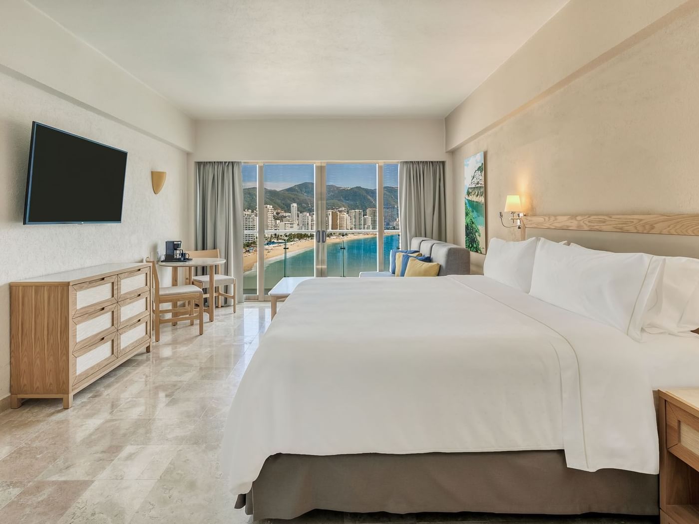 TV-facing bed with workspace and sea view in Deluxe Room,1 King at Fiesta Americana Brand