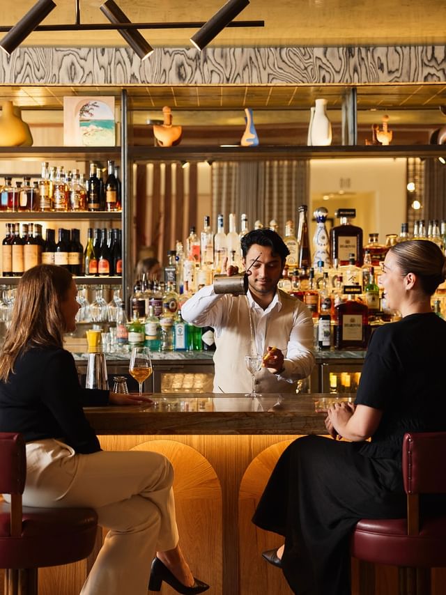 Cibaria\'s 55 North Bar at Elysium Manly with guests on red stools by a marble counter, highlighting top bistro Manly