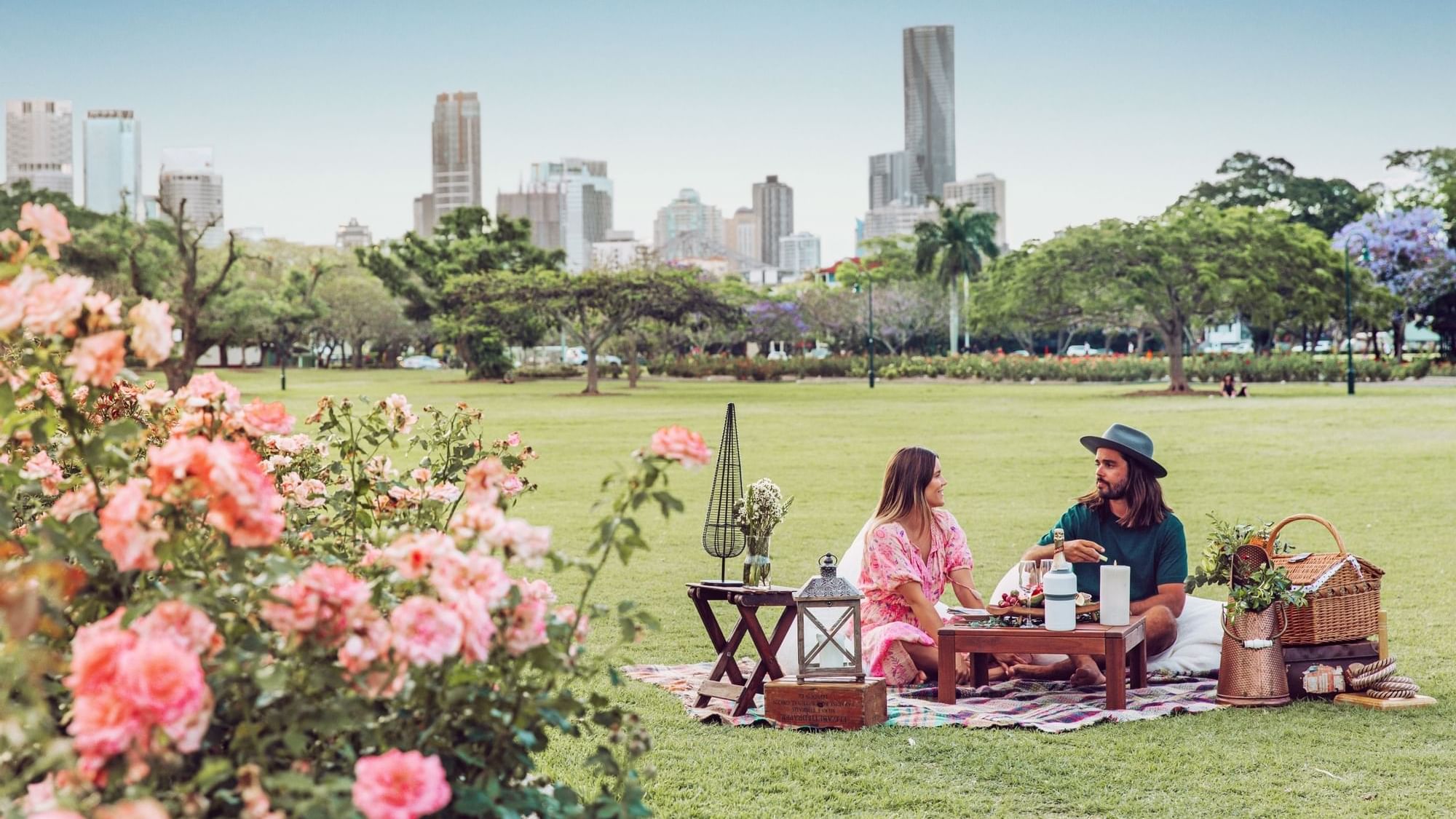 Couple enjoying a picnic in New Farm with a city skyline near Sofitel Brisbane Central