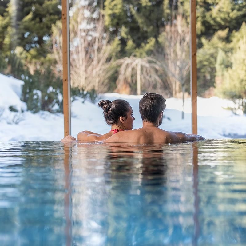 A couple relaxing in the pool at Falkensteiner Hotels