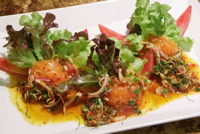 A dish served with lettuce, tomatoes, and mixed vegetables at Amora Neoluxe Hotel Bangkok