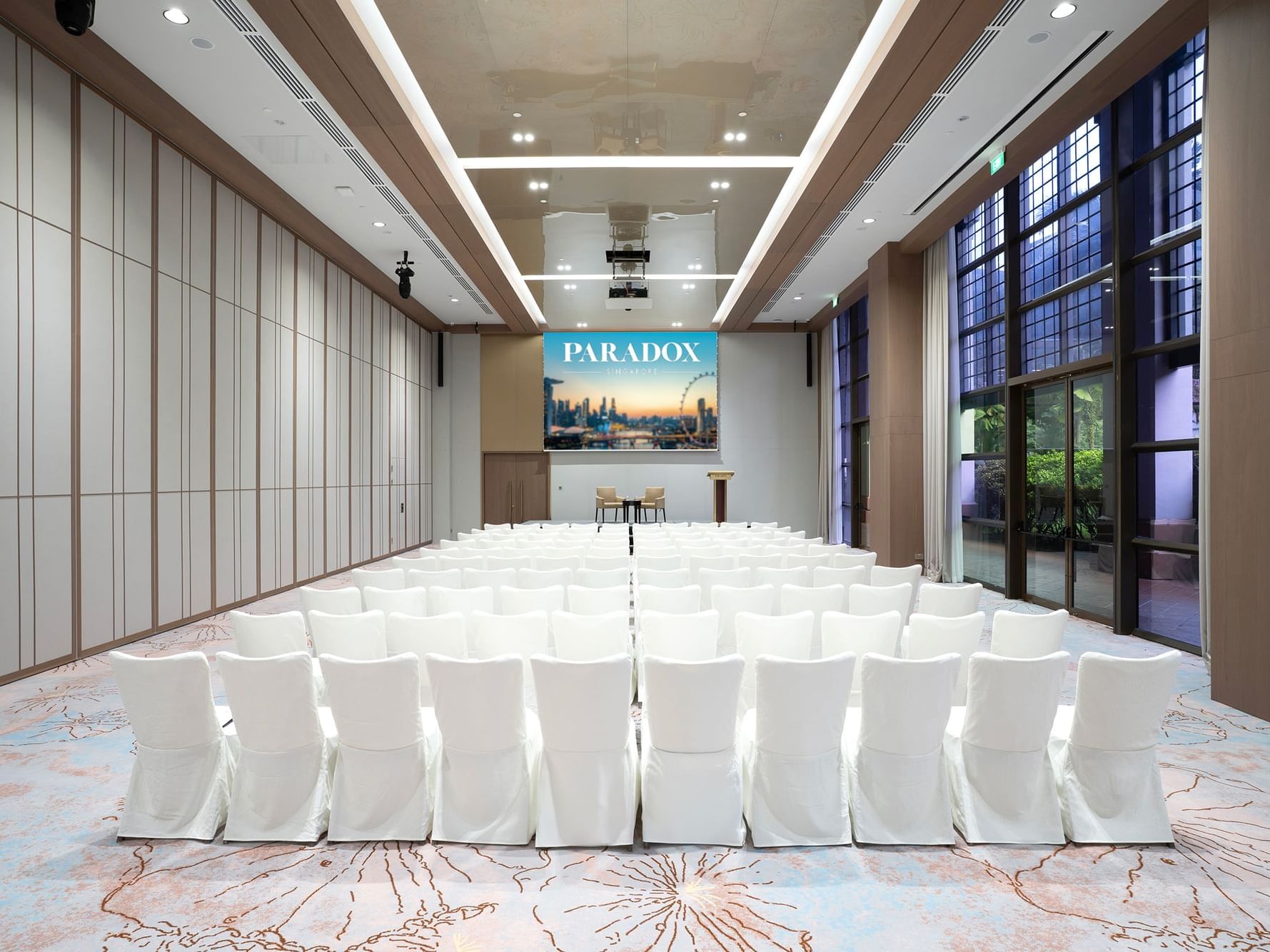 Theatre-style seating arrangement in the ballroom at Paradox Singapore, with rows of chairs facing a presentation stage.