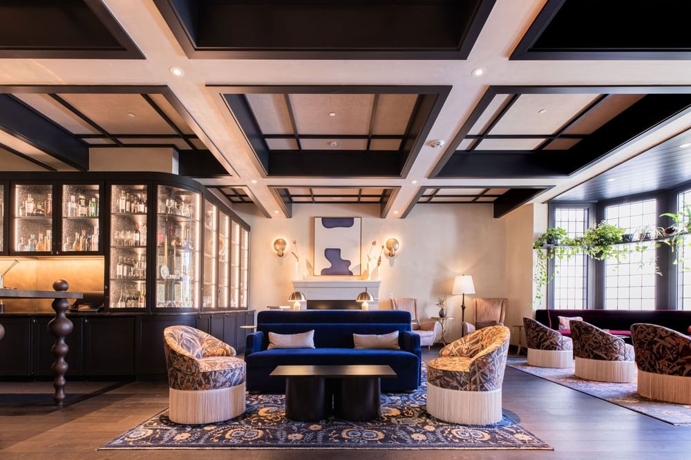 La Mirada Tapas Bar lounge featuring stylish seating with a warm fireplace, and a well-stocked bar at El Prado Hotel