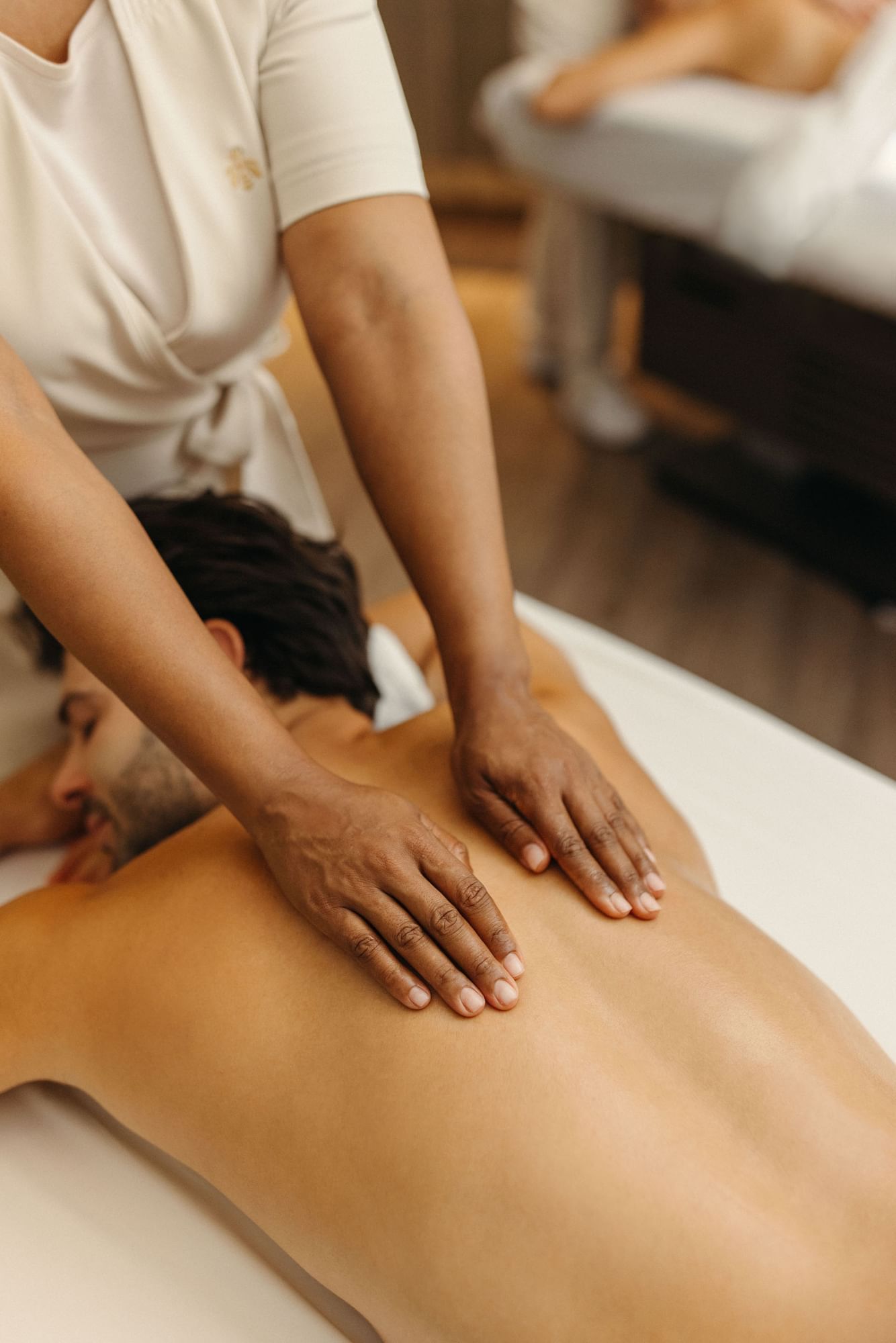 Person receiving a back massage in Guerlain spa at Hotel X Toronto