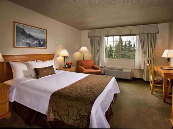 Bed and desk in hotel room with window