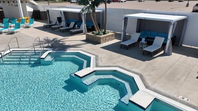 Sunny pool area with turquoise water, cabanas, and sun loungers at Off Shore Resort