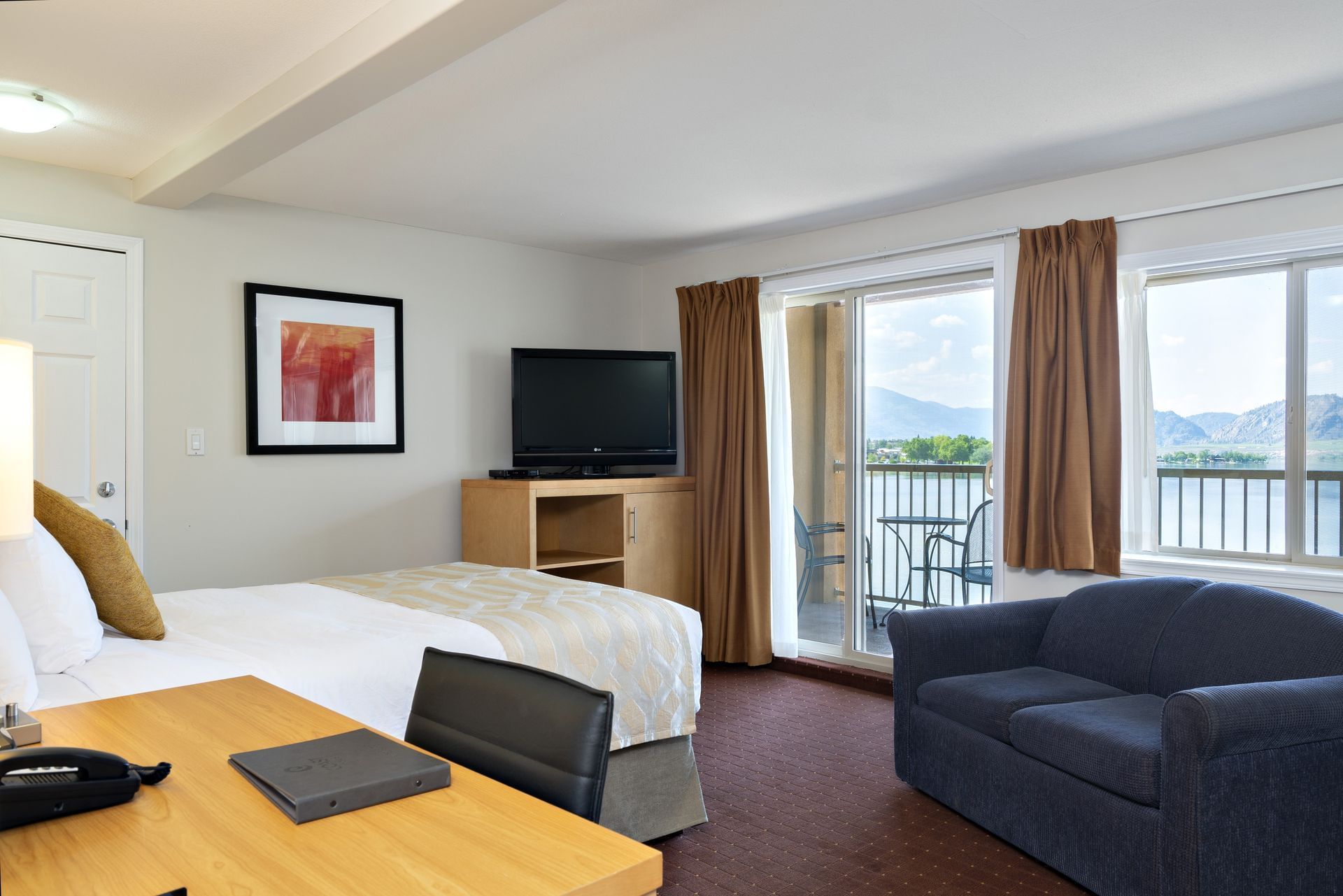 Bed, sofa and TV with lake view