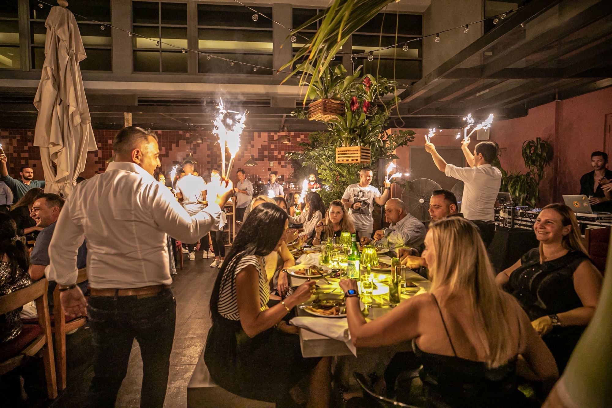 a group of people sitting at a table with sparklers