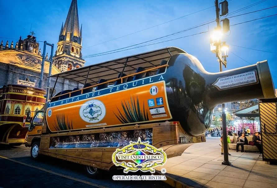 Botella grande dispuesta en un camión con asientos cerca de One Hotels