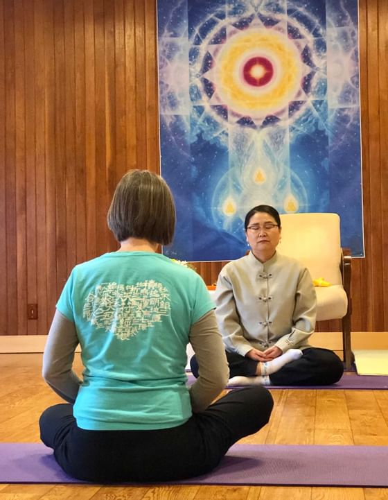 2 women sitting face to face & meditating at Honor’s Haven Retreat