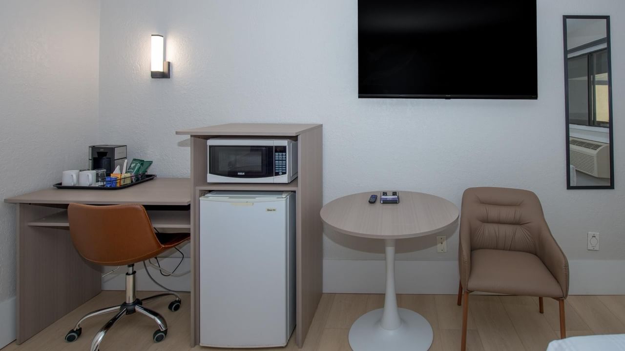 Guest room at Coast Red Deer Hotel with desk, microwave, mini fridge and TV