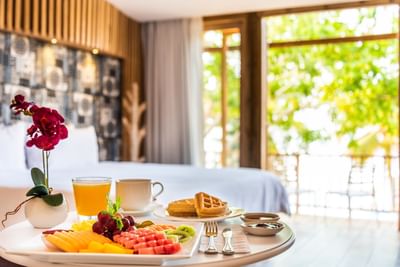Breakfast with fruits, waffles and orange juice served on a table in the room at Hotel Isla Del Encanto