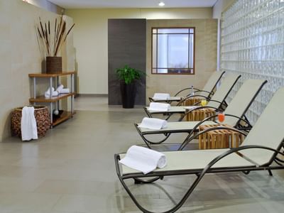 Spa relaxation at Habitel Prime Hotel with chaise lounges, refreshing drinks & neatly arranged towels