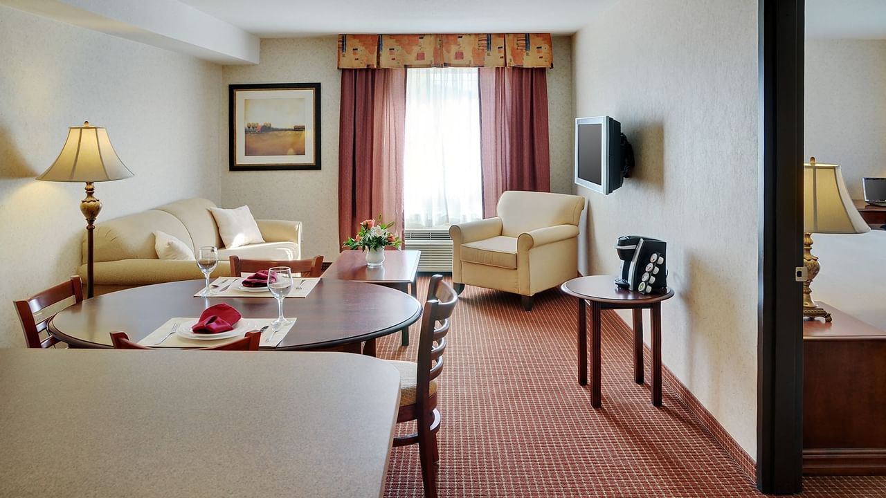 Grimshaw hotel room with table, seating area and bedroom