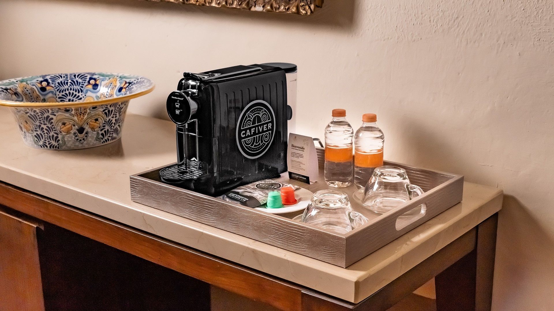King Presidential Suite coffee station with a Cafiver espresso machine, water bottles, and glass cups at Quinta Real Puebla