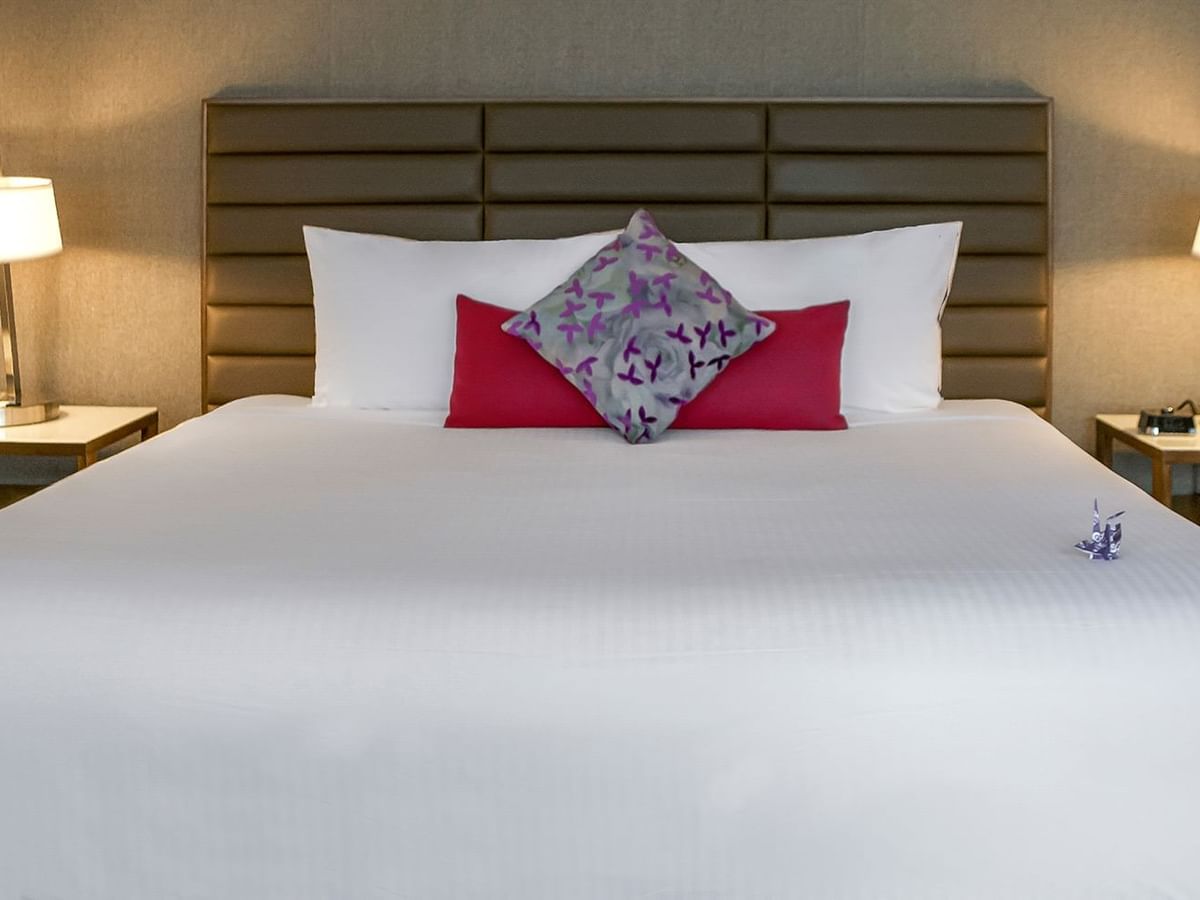 Hotel bedroom with bed, night stand, and lamps