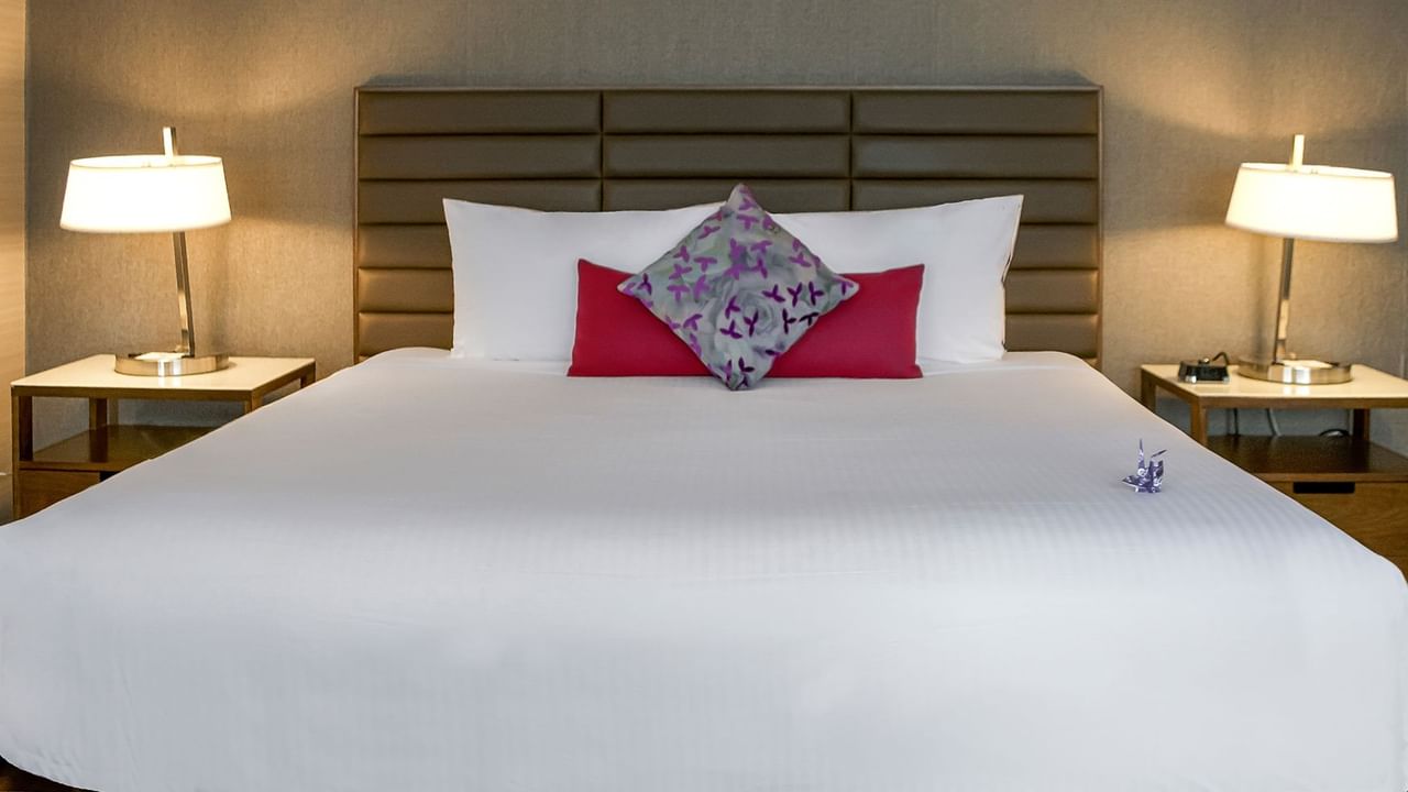 Hotel bedroom with bed, night stand, and lamps