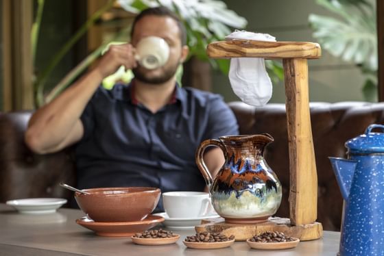 man drinking coffee while brewing coffee